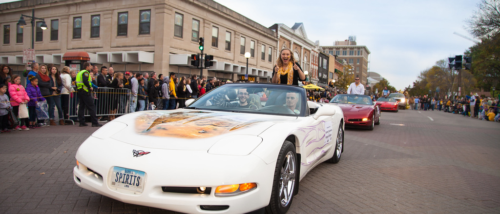 car drives down street during parade